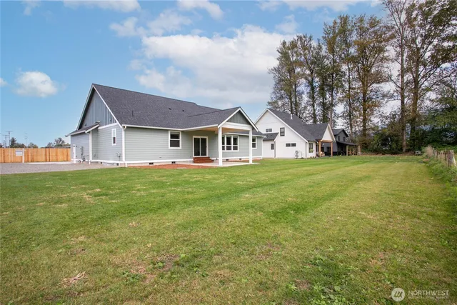 a view of a house with a big yard and large trees