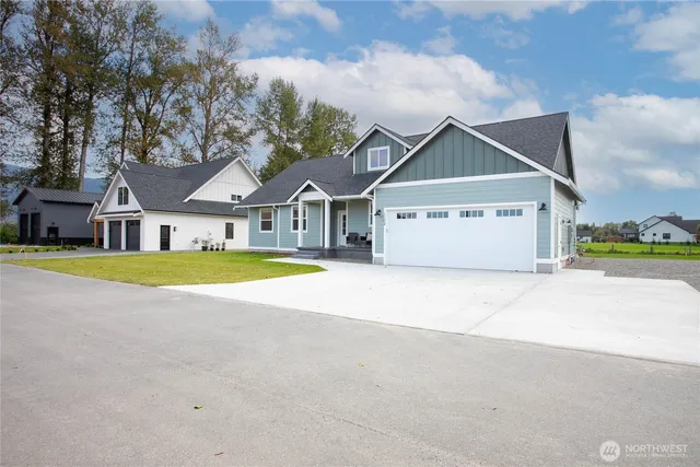 a view of a white house with a large pool and large trees