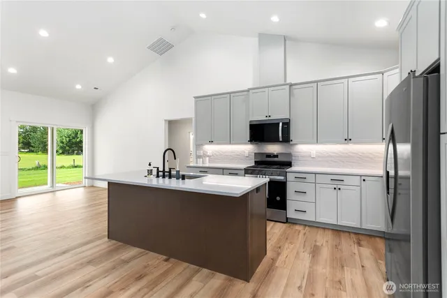 a kitchen with stainless steel appliances granite countertop a sink stove and refrigerator