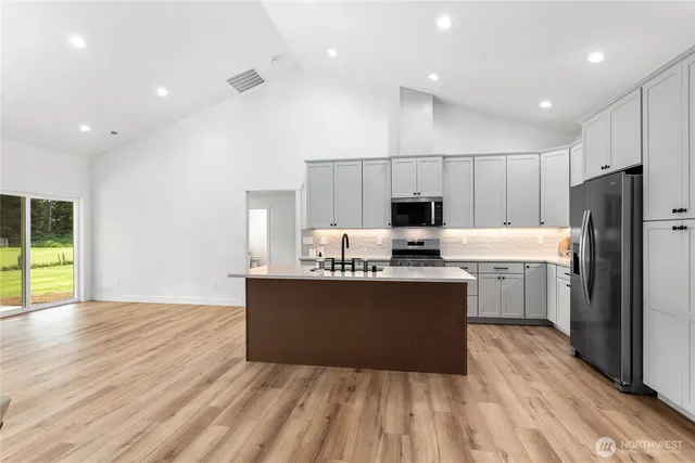 a kitchen with stainless steel appliances a refrigerator sink and microwave