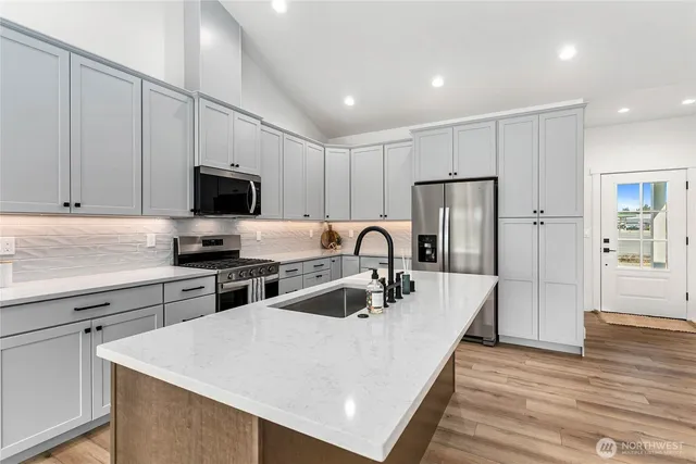 a kitchen with sink a refrigerator and chairs
