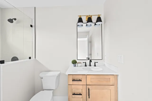 a bathroom with a sink toilet and mirror