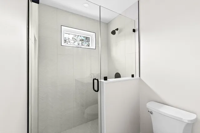 a bathroom with a shower a toilet and a sink