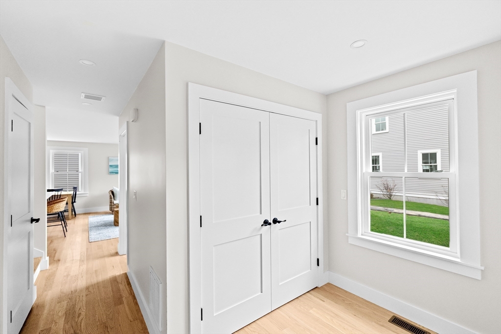 19 Ford Place, Unit 1 Scituate, MA 02066 - Photo 31 of 35 a view of a hallway with wooden floor and dining room view