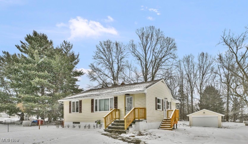 View of front of property with an outdoor structure and a detached garage