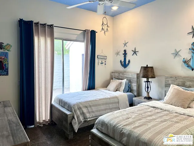 a bedroom with two beds and a chandelier