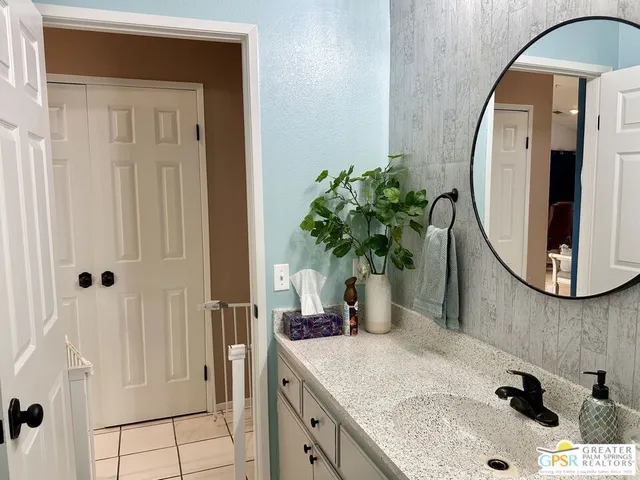 a bathroom with a granite countertop sink a mirror and vanity
