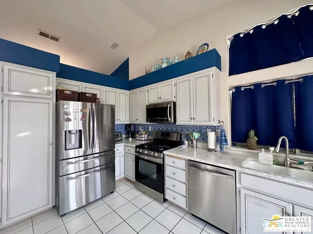 a kitchen with stainless steel appliances a refrigerator sink and microwave