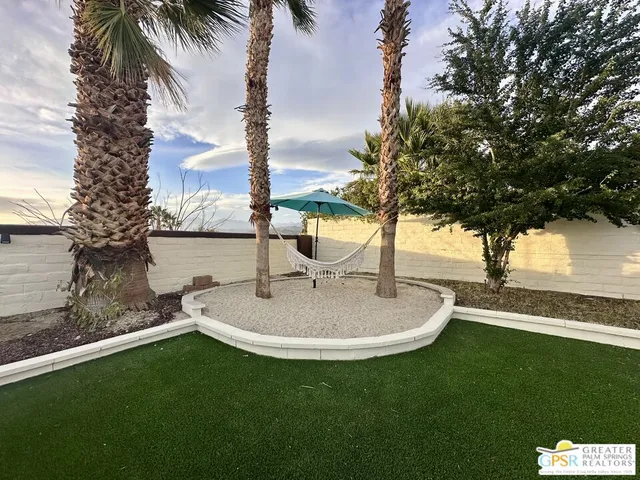 a backyard of a house with table and chairs