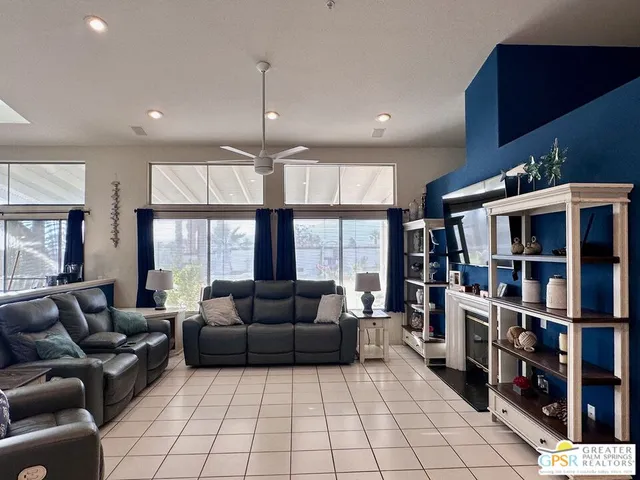 a living room with furniture a large window and a book shelf