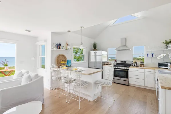 a living room with furniture a fireplace and a kitchen view