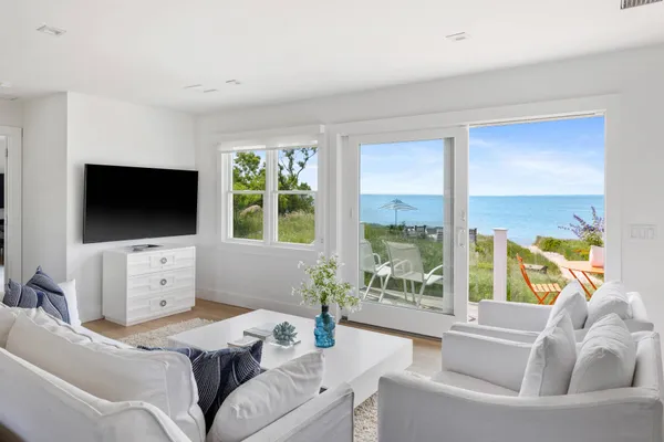 a living room with furniture a flat screen tv and a floor to ceiling window
