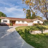 a front view of a house with a yard and potted plants