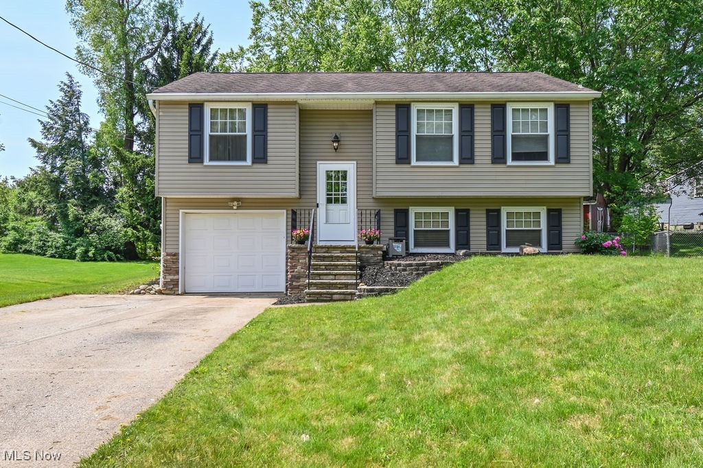 2610 Norton Road Stow, OH 44224 - Photo 1 of 41 Split level home with a front yard, an attached garage, concrete driveway with extra parking space, and stone siding. Flower beds planted with perennials & was mulched before listing.