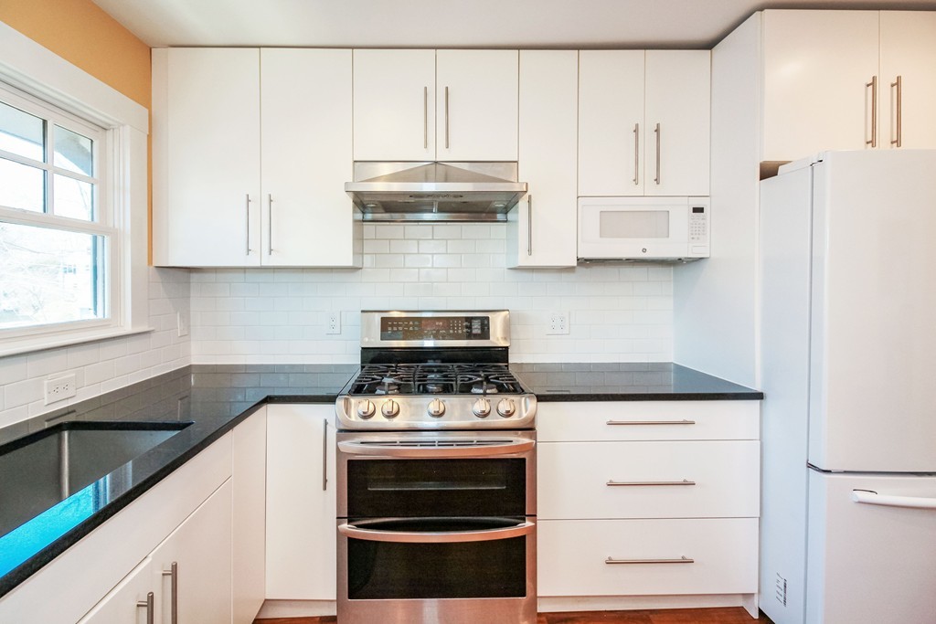 20 Stoneleigh Road, Unit 20 Newton, MA 02465 - Photo 1 of 30 a kitchen with granite countertop white cabinets and white appliances