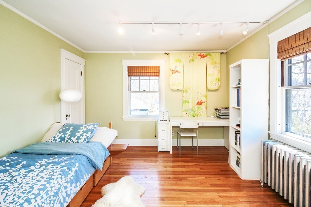 20 Stoneleigh Road, Unit 20 Newton, MA 02465 - Photo 16 of 30 a bedroom with a bed and a table with windows