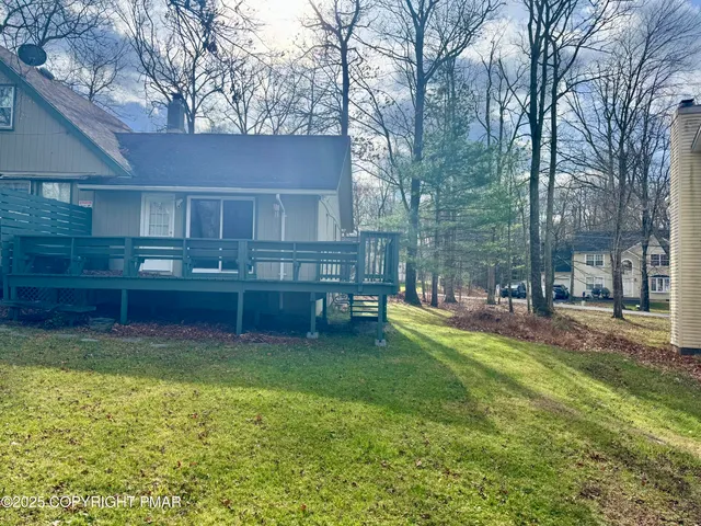 a view of a house with a yard and a wooden fence