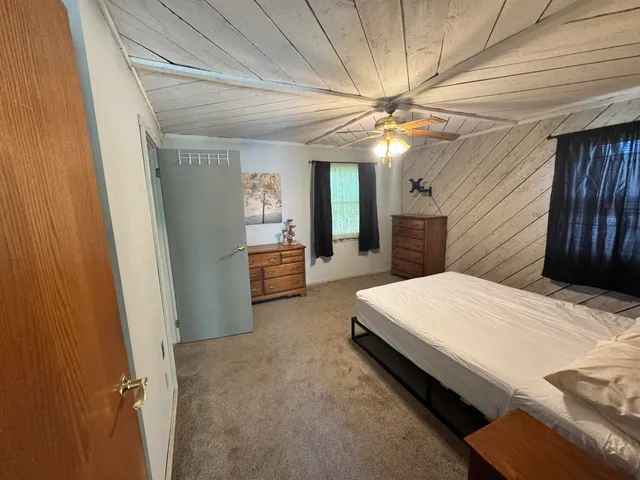 a spacious bedroom with a bed and a chandelier