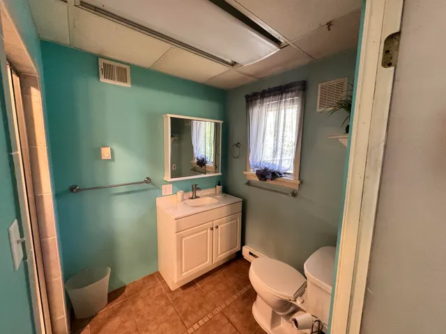 a bathroom with a toilet sink and mirror