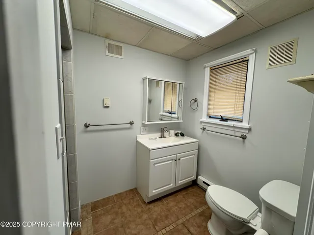 a bathroom with a toilet sink and mirror