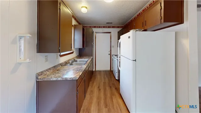 a view of a kitchen from a hallway