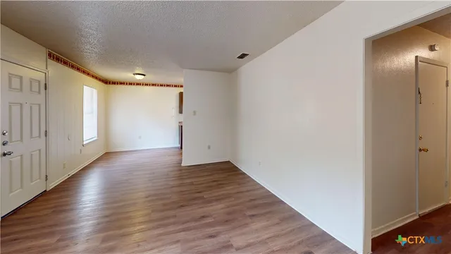 a view of an empty room with wooden floor