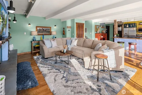 a living room with furniture a flat screen tv and a fireplace