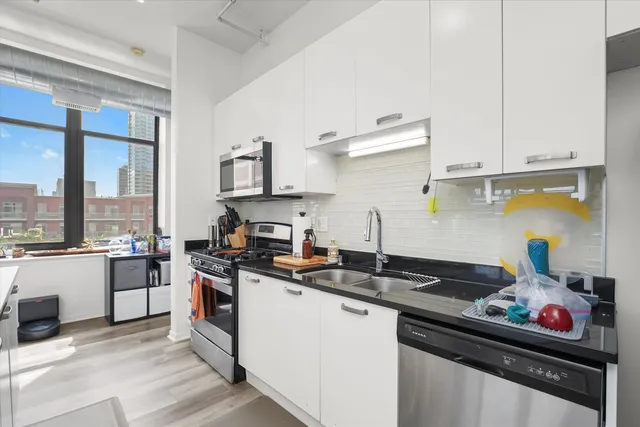 a kitchen with a sink stove top oven and cabinets