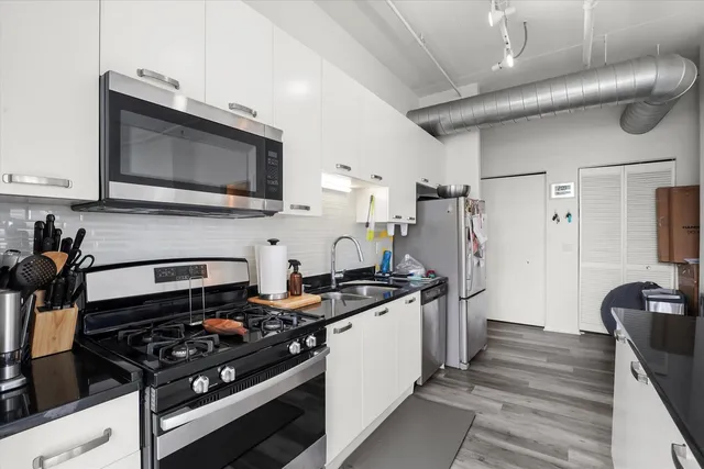 a kitchen with stainless steel appliances a stove a sink and a microwave