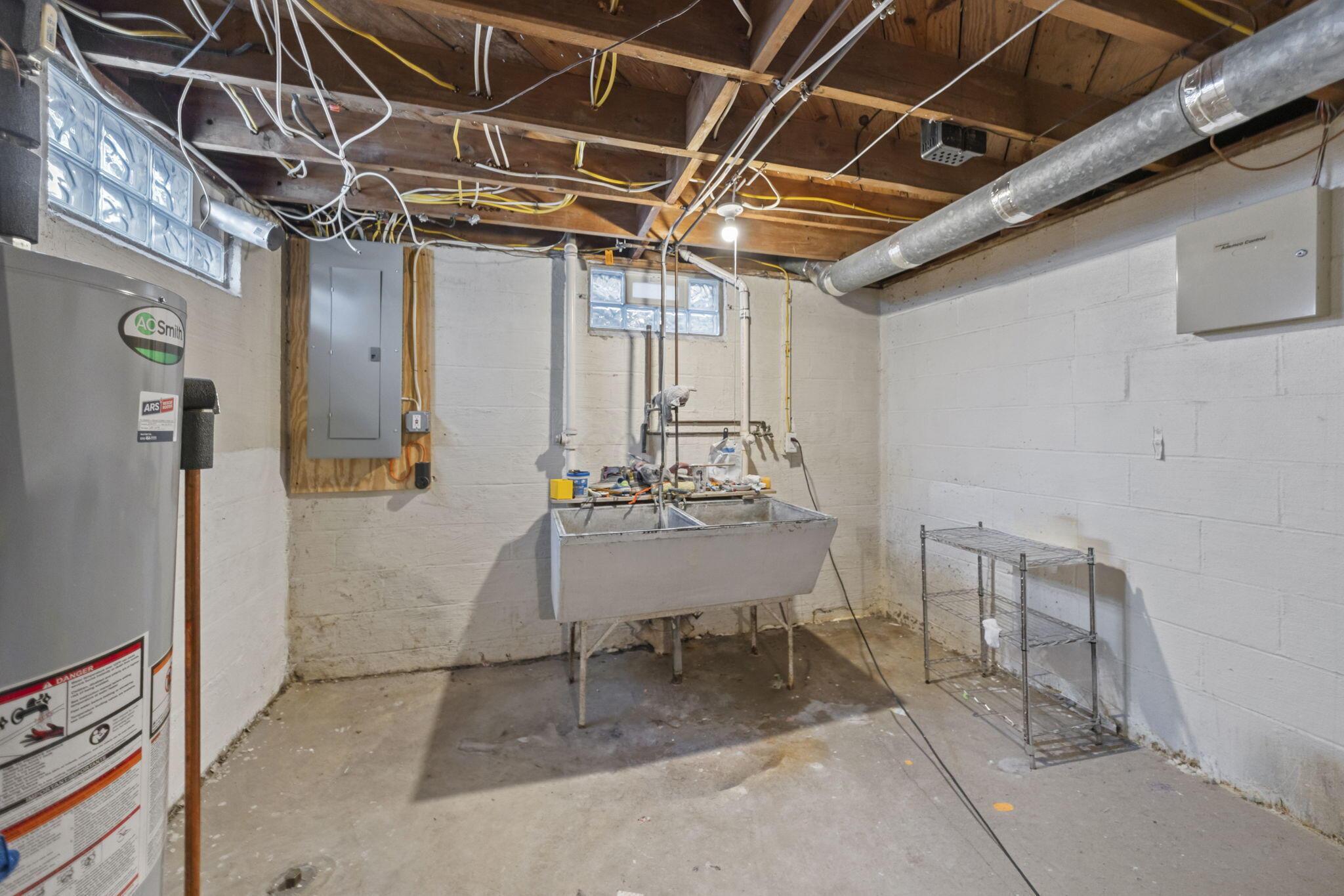 40 South Kellner Road Columbus, OH 43209 - Photo 40 of 57 Basement featuring exposed ceiling joists, concrete flooring, a utility sink, and glass block windows