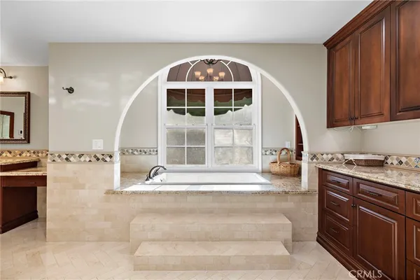 a bathroom with a tub sink and mirror