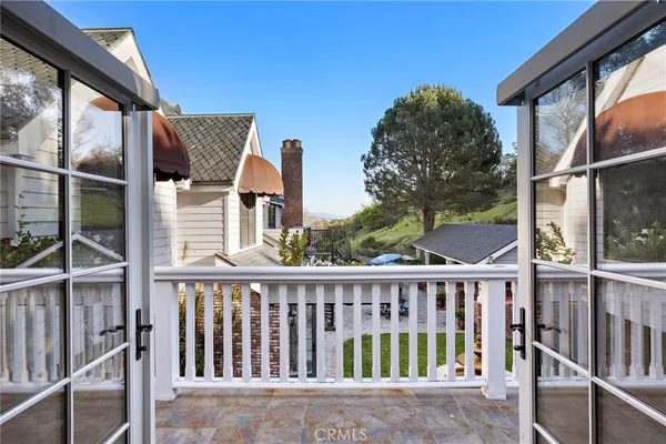 a view of a patio with table and chairs with plants and wooden fence