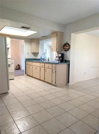 a kitchen with white cabinets a sink and dishwasher