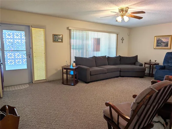 a living room with furniture a large window and a chandelier