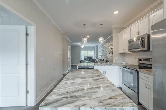 a large kitchen with stainless steel appliances lots of counter space and a sink