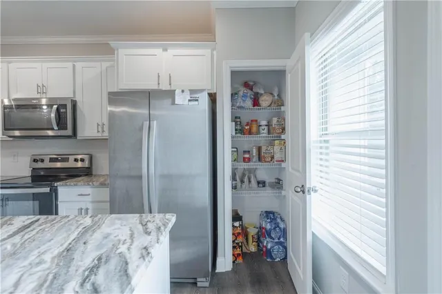 a kitchen with stainless steel appliances a refrigerator and a window