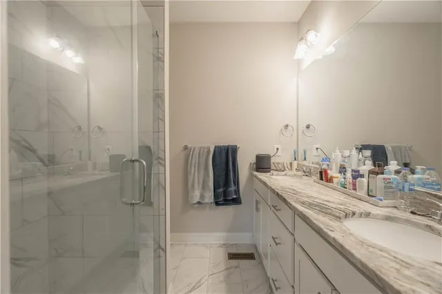 a bathroom with double vanity and a shower