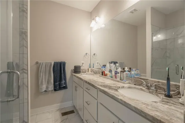 a bathroom with double vanity and a mirror