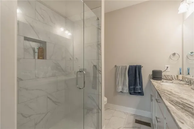 a bathroom with a granite countertop shower a sink and a mirror