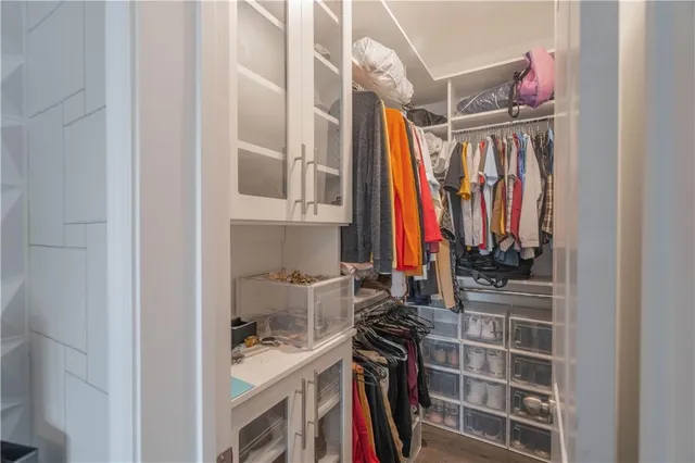 a view of walk in closet with clothes and shoes