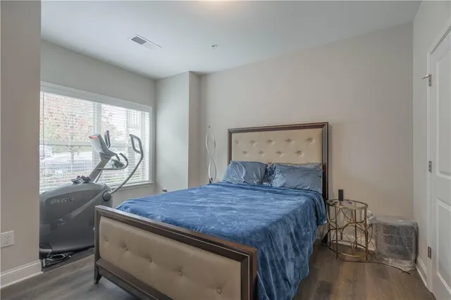 a bedroom with a bed and large windows