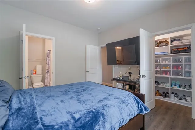 a bedroom with a bed and a flat tv screen on dresser