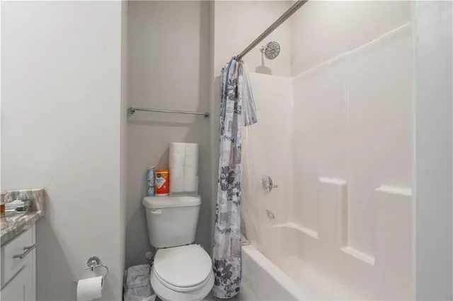 a white toilet sitting next to a bath tub