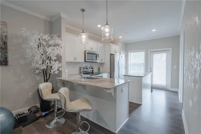 a kitchen with kitchen island a stove a table and chairs in it