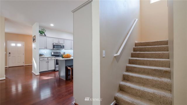 a view of kitchen with sink and refrigerator