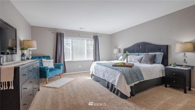 a bedroom with a bed and a large window