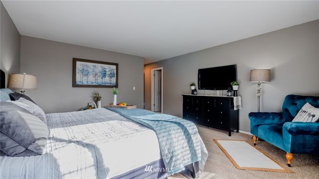 a bedroom with a bed and a flat screen television