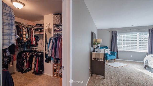 a view of walk in closet with clothes and shoes