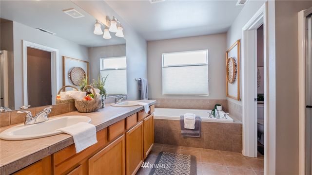 a bedroom with a bed and a mirror on the dresser