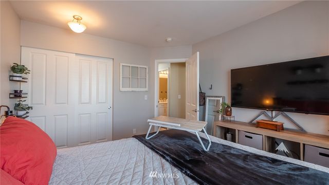 a bedroom with a bed and a flat screen tv